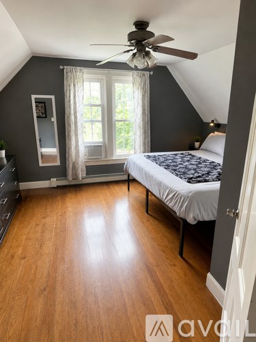A bedroom with a bed, dresser, and window.