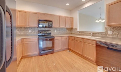 A kitchen with wooden cabinets and a stainless steel refrigerator.