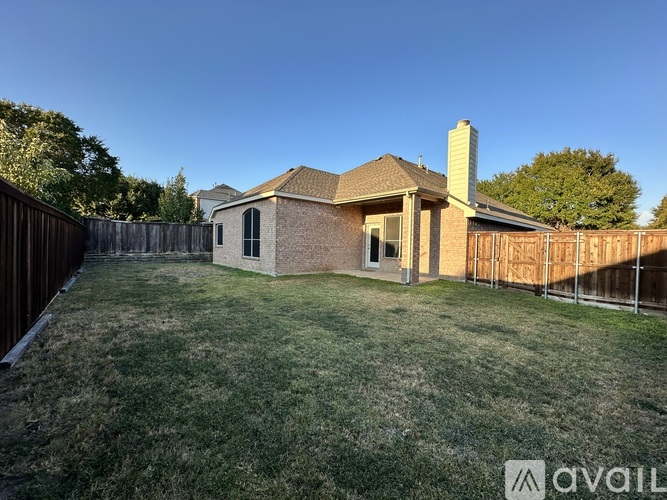 A house with a brown roof and a brown fence is in the image.