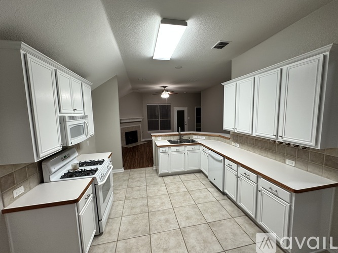 A kitchen with white cabinets and appliances.