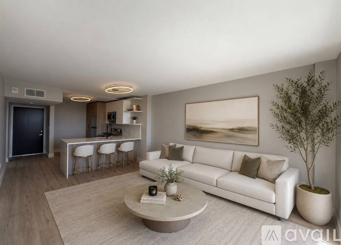 A modern living room with a white sofa, a coffee table, and a painting on the wall.