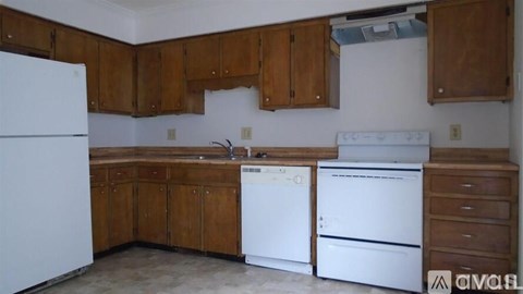 A kitchen with wooden cabinets and white appliances.