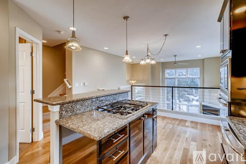 A kitchen with a granite countertop and a stove top oven.