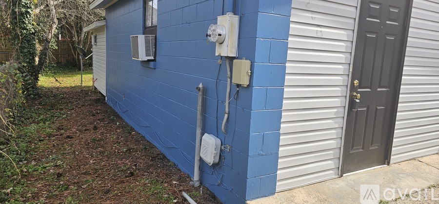 A blue building with a grey door and a window.