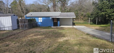 A blue house with a grey roof and a white shed in the backyard.