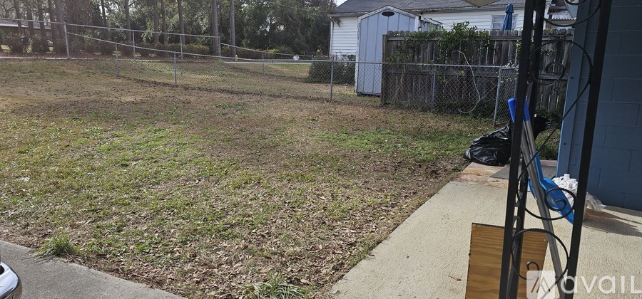 A backyard with a fence and a shed.