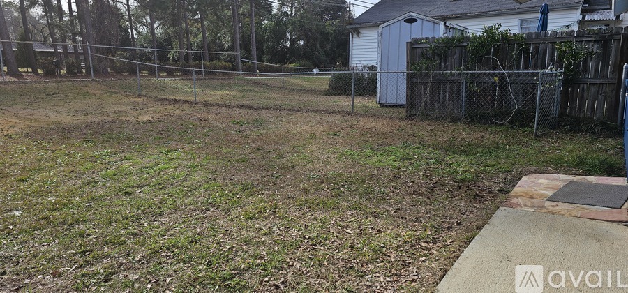 A fenced yard with a house in the background.