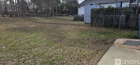 A fenced yard with a house in the background.