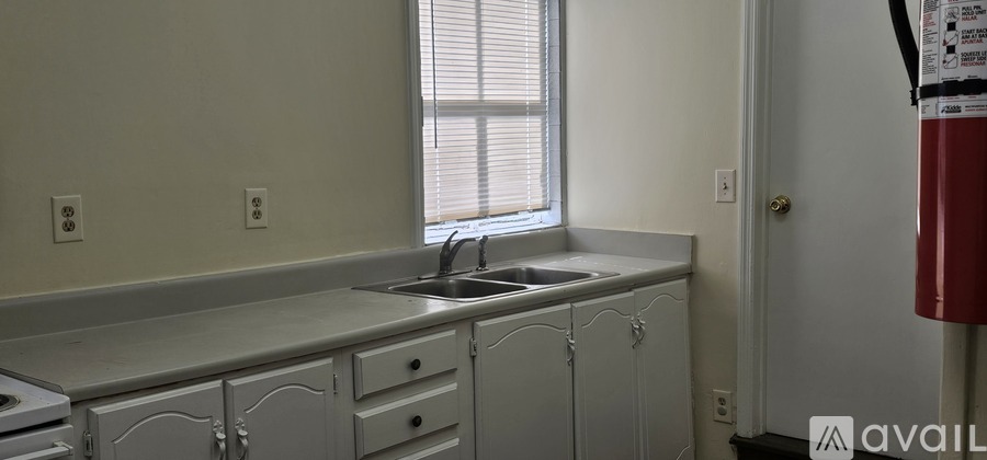 A kitchen with white cabinets and a window.