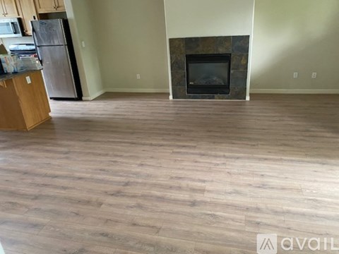 A living room with a fireplace and a wooden floor.