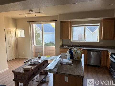 A kitchen with a wooden island and a dining table with chairs.