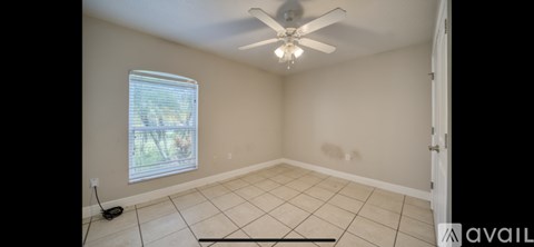 A room with a ceiling fan and a window.