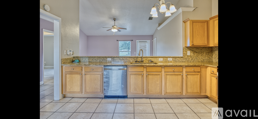 A kitchen with wooden cabinets and a marble countertop.