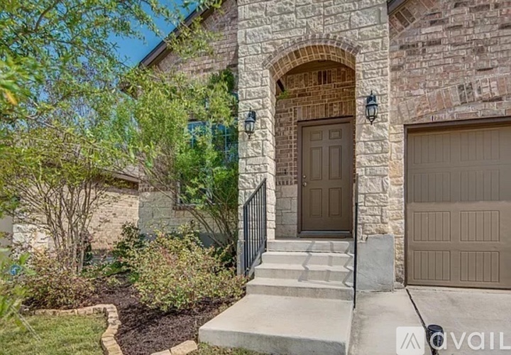 A house with a brown door and a stone archway above the steps leading to it.