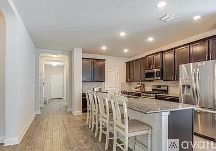 A kitchen with a white counter and stainless steel appliances.