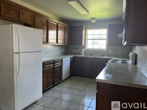 A kitchen with a white fridge and wooden cabinets.