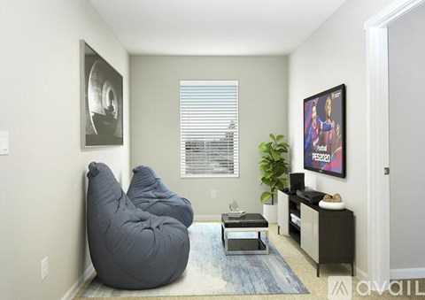 A living room with a grey bean bag chair and a flat screen TV mounted on the wall.
