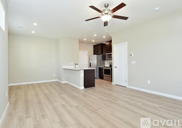 A spacious room with a ceiling fan and lighting fixture.