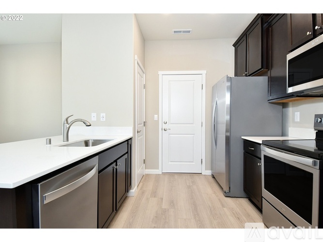 A kitchen with a white countertop and stainless steel appliances.