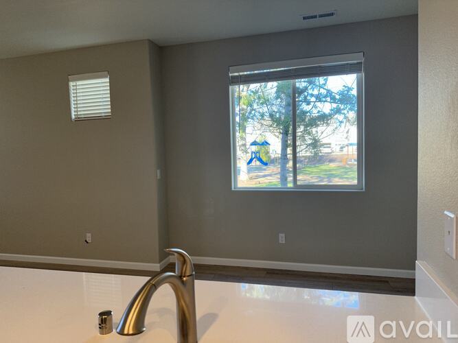 A bathroom with a window overlooking a playground.
