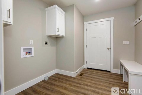 A room with a white door and a white cabinet above it.