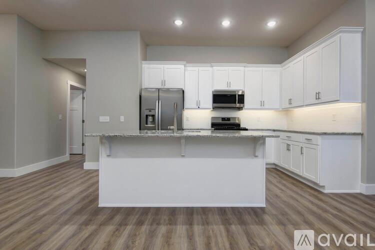 A kitchen with white cabinets and a wooden floor.