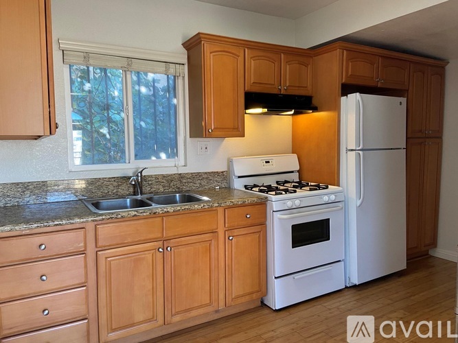 A kitchen with wooden cabinets and a white fridge.