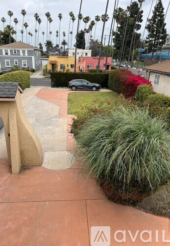 A residential street with a car parked on the side.