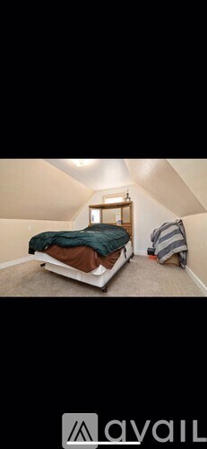 A bedroom with a bed and a window.