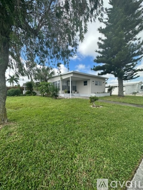 A house with a white exterior and a green lawn in front.