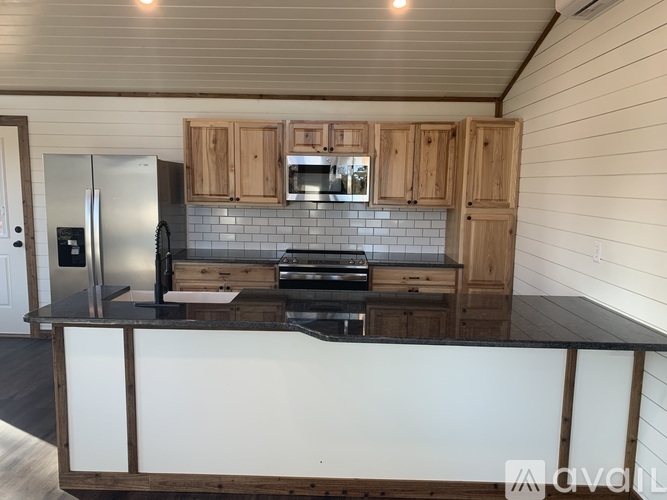 A kitchen with wooden cabinets and a black countertop.