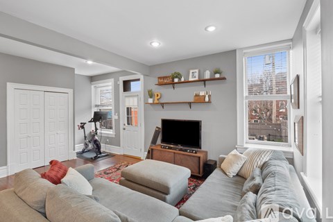 A living room with a grey couch and a fireplace.