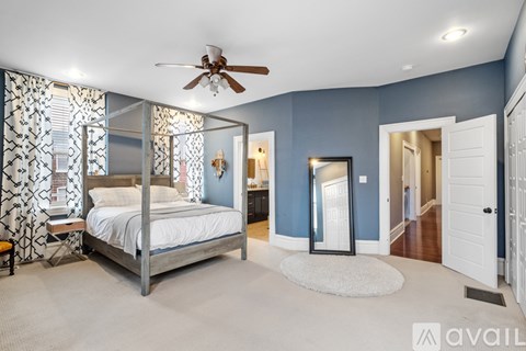 A bedroom with a large bed and a ceiling fan.