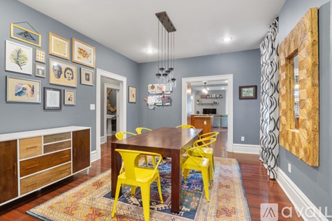 A dining room with a wooden table and yellow chairs.