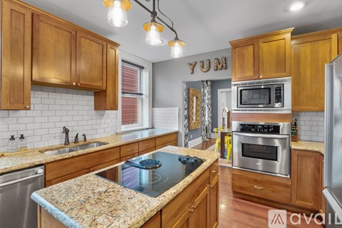 A kitchen with wooden cabinets and granite countertops.
