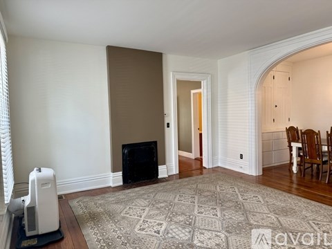 A living room with a fireplace and a rug on the floor.