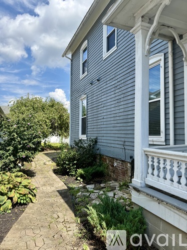 A house with a white porch and a garden in front.
