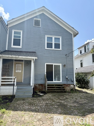 A blue house with a front porch and a small front yard.