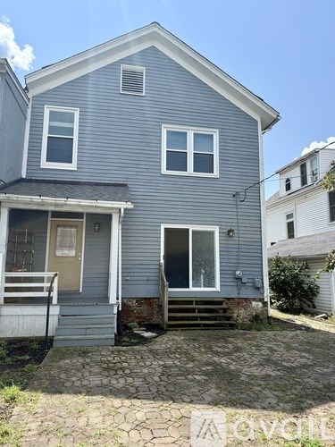 A blue house with a front porch and a small front yard.