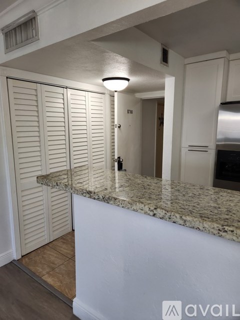 A kitchen with white cabinets and a granite countertop.
