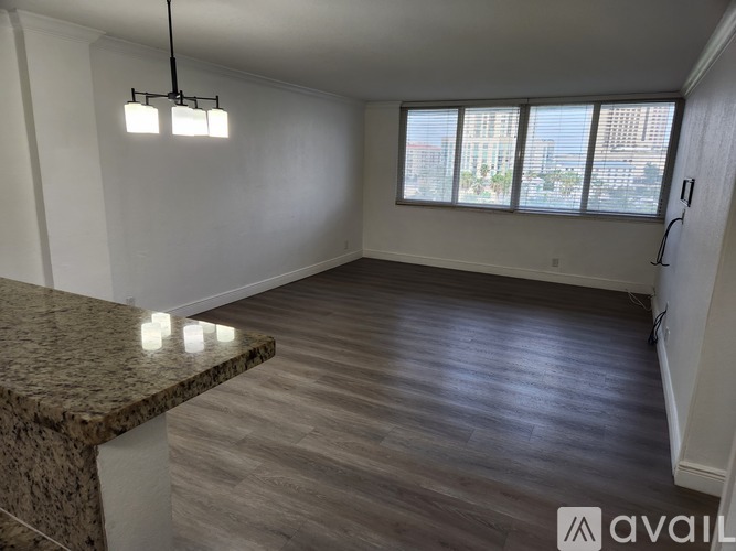 A spacious room with a marble countertop and wooden flooring.