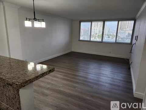 A spacious room with a marble countertop and wooden flooring.