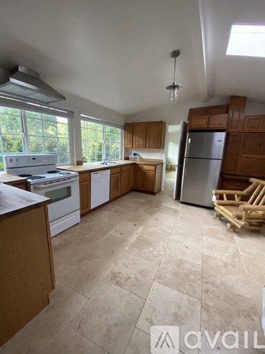 A kitchen with wooden cabinets and a tiled floor.