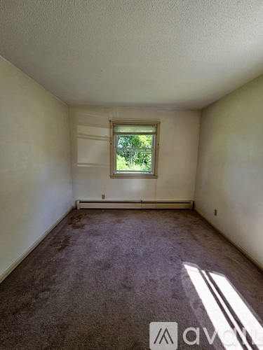 A room with a window and carpeted floor.