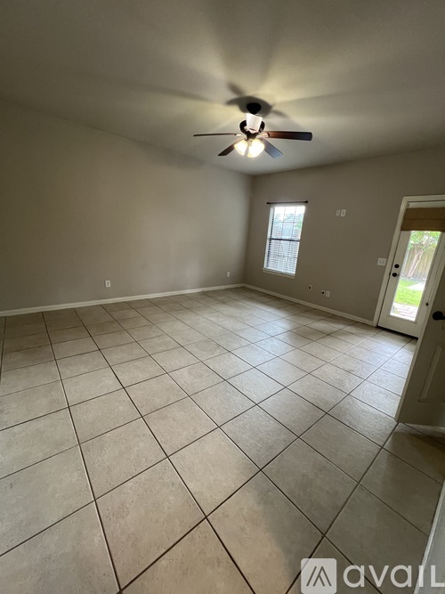 A room with a ceiling fan and tiled floor.