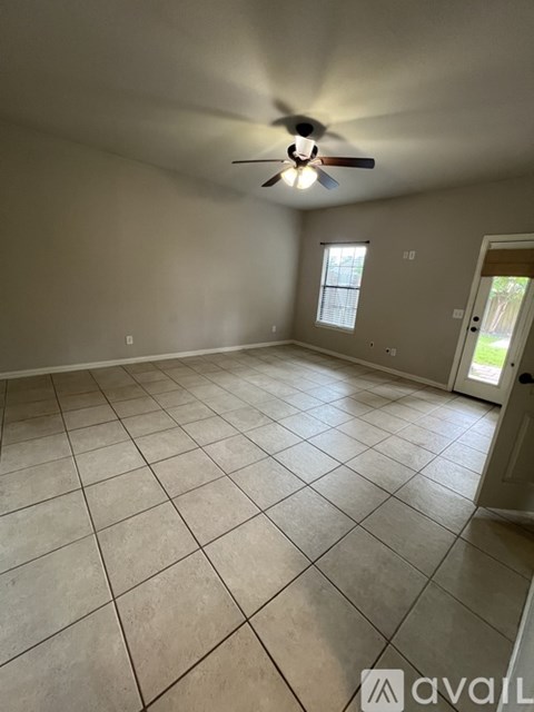 A room with a ceiling fan and tiled floor.