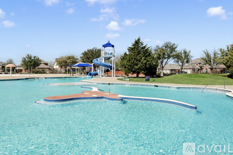 A large swimming pool with a diving board and a water slide.