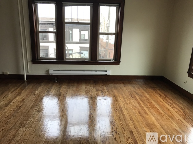 A room with wooden floors and a large window.