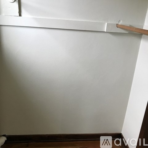 A white wall with a wooden handle on it.