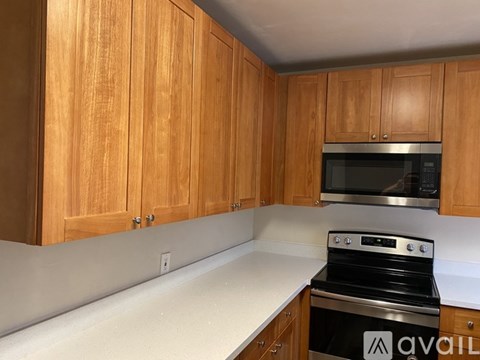 A kitchen with wooden cabinets and a stove top oven.